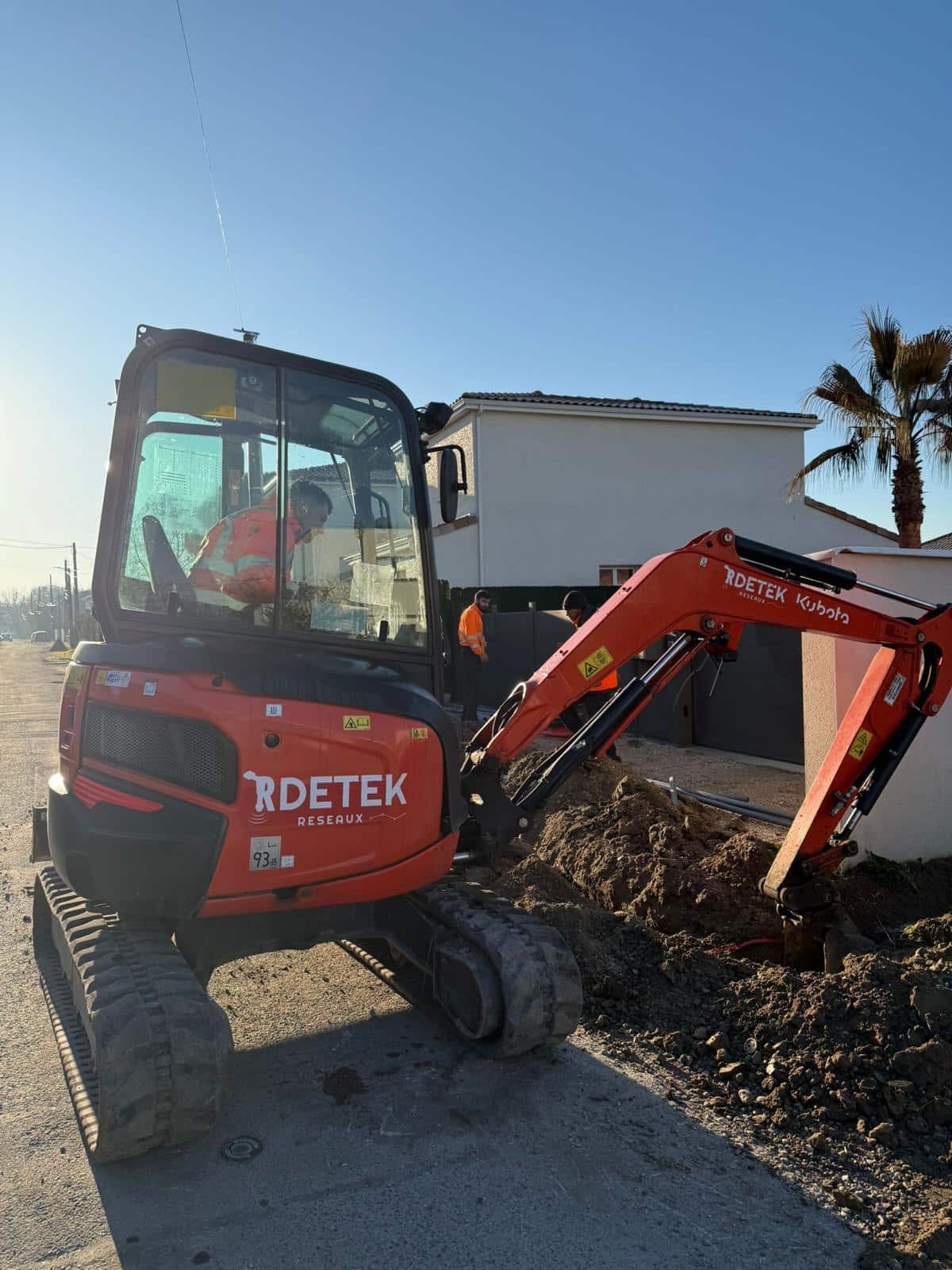 Mini-pelle Kubota de RDETEK Réseaux effectuant des travaux de terrassement et creusement près d'une habitation.