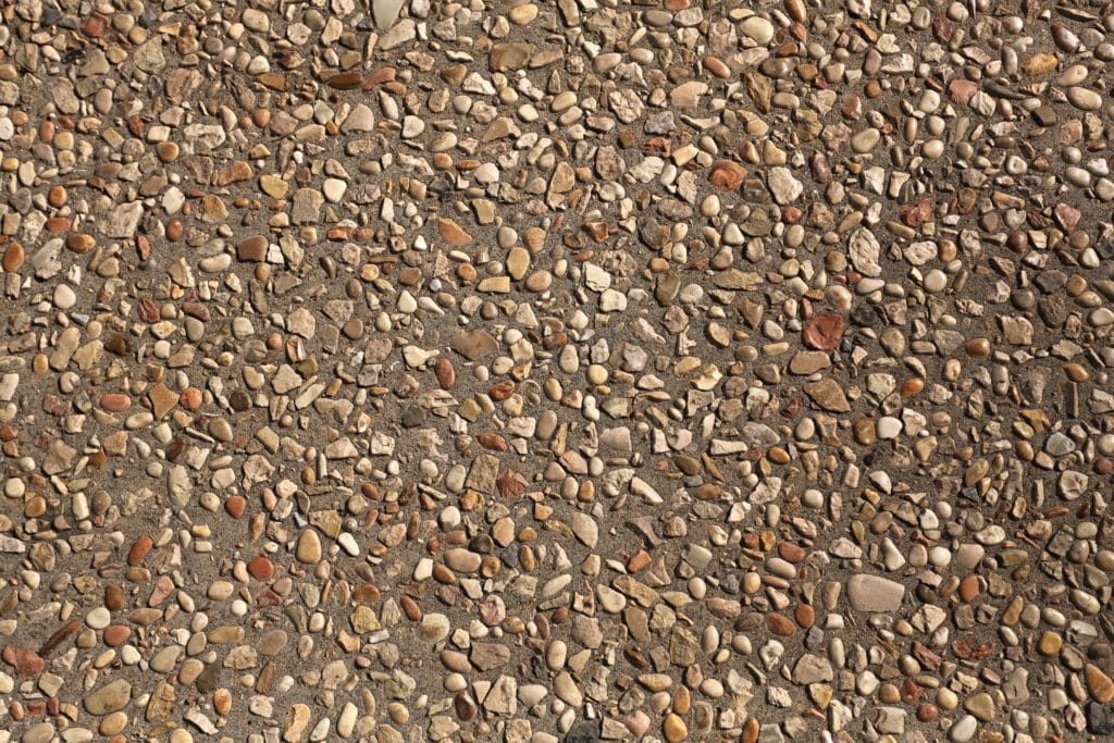 Béton Désactivé : Texture de Gravillons et Galets Colorés Gros plan d'une surface en béton désactivé avec des gravillons et galets multicolores pour une texture naturelle.