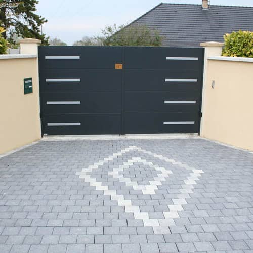 Portail Alu Noir Moderne et Pavage d'Allée en Damier Portail battant en aluminium noir moderne avec inserts gris et pavage en damier sur une allée de maison.