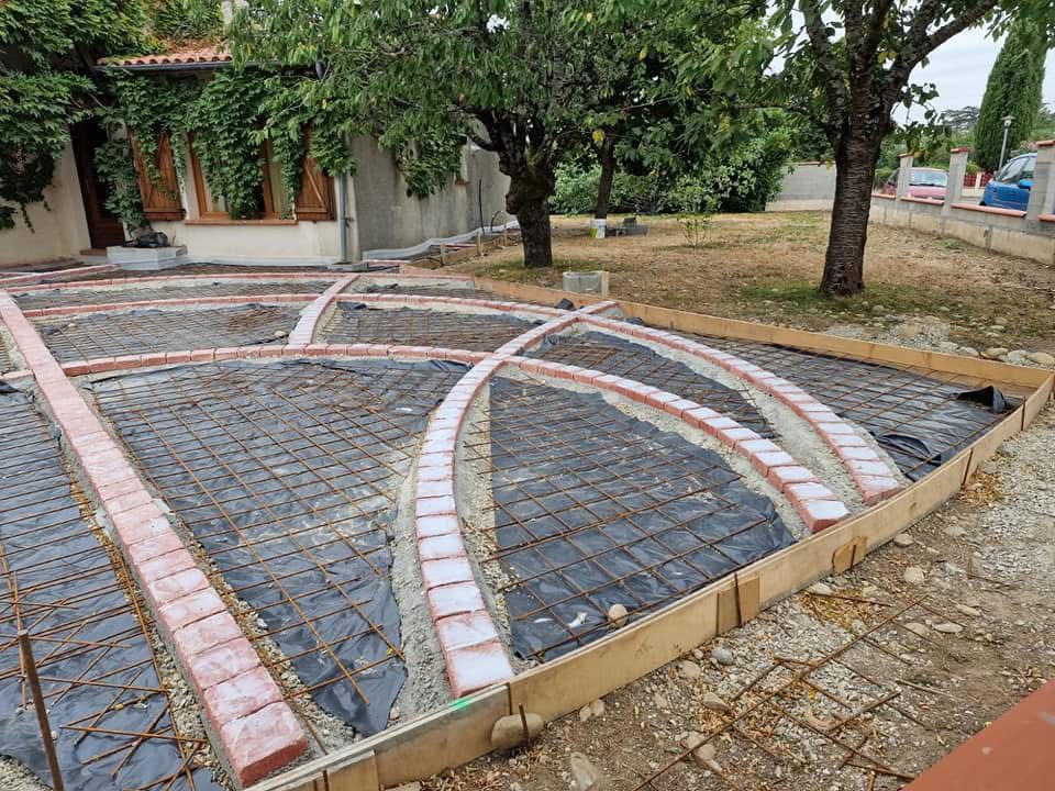 Préparation Dalle Béton Décorative : Ferraillage et Briques Préparation d'une dalle béton décorative avec ferraillage, briques en arcs de cercle et coffrage bois pour terrasse.